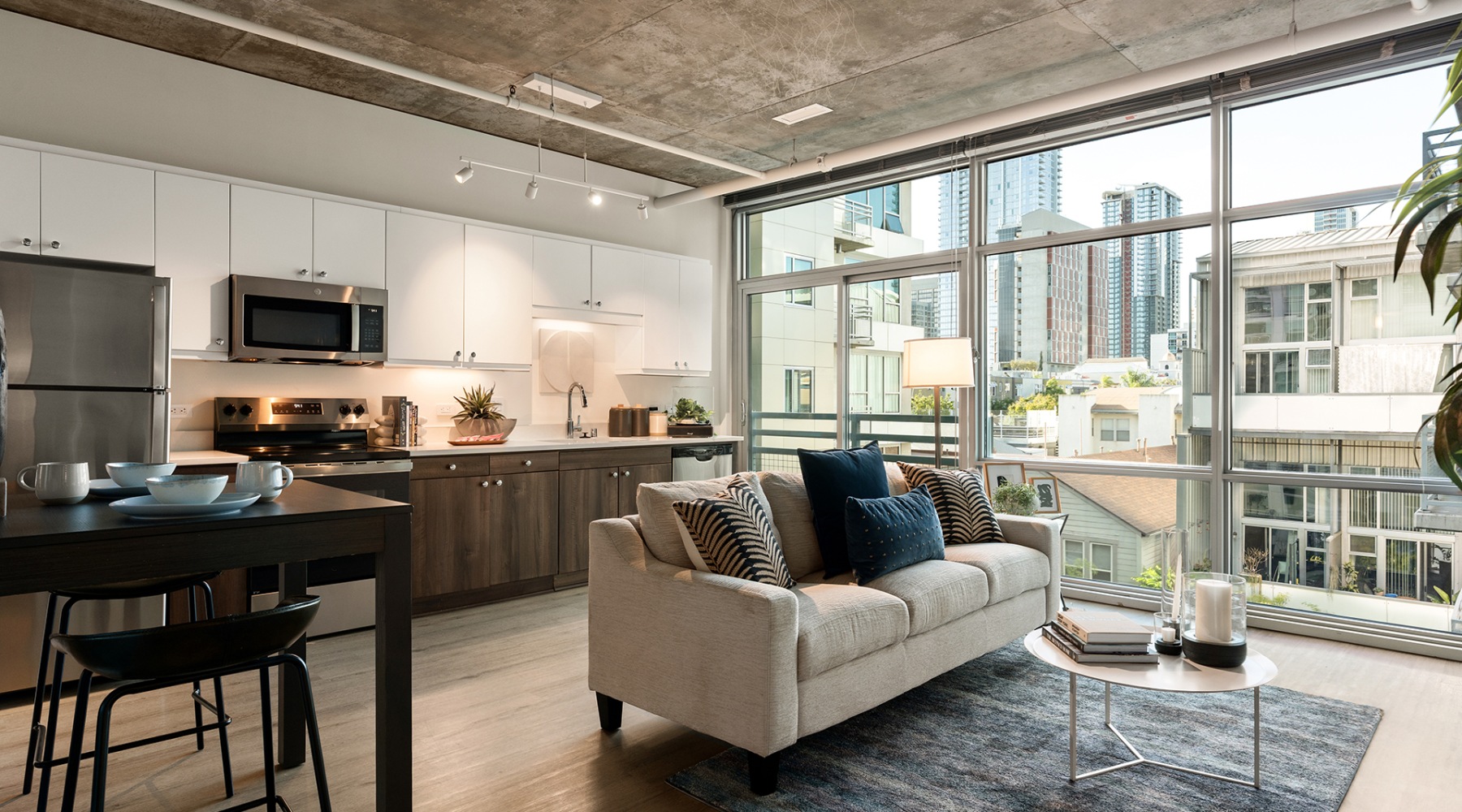 A spacious renovated living space and kitchen with large floor to ceiling windows