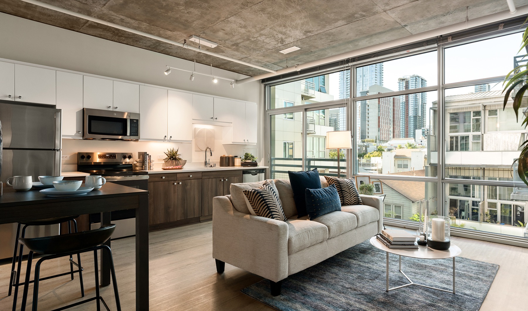 a renovated unit with a modern kitchen, couch, and floor to ceiling windows