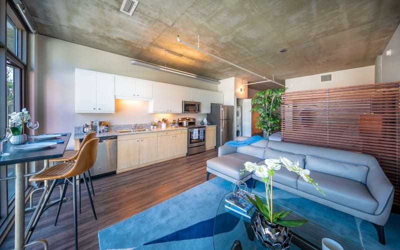a spacious living room with a couch and kitchen